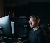 Desarrollador trabajando frente a un monitor en un estudio con poca luz